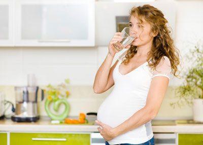 Беременная запивает лекарство