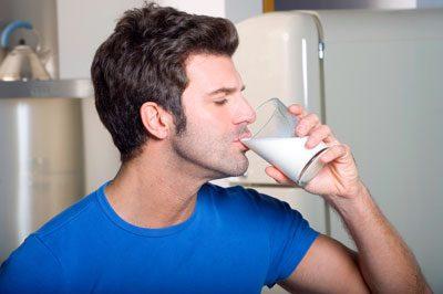 Мужчина пьет молоко